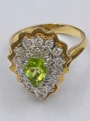 A 14ct yellow gold peridot and diamond pear shaped ring.