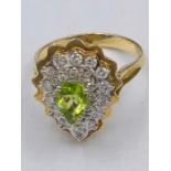 A 14ct yellow gold peridot and diamond pear shaped ring.