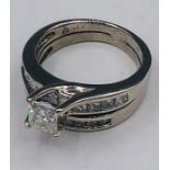 Two 14ct white gold rings one with princess cut central stone flanked by diamonds in the form of and