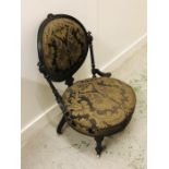 A Late Victorian French Style ebony nursing chair on fluted legs.