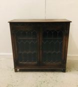 A Carved Oak glazed display cupboard