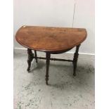 A Walnut drop leaf table on castors.