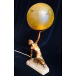 An Art Deco Lamp with a figure of a lady holding a crackle glass globe shade.