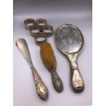 A selection of silver items to include napkin rings, dressing table mirror etc