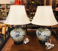 Two large Blue and White Chinese style vases on wooden bases with brass fittings.