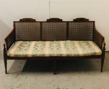 A 19th Century three seater caned Bergere sofa in satin wood and hand painted with urns and flowers