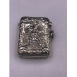 A silver vesta case with embossed image of a golfer