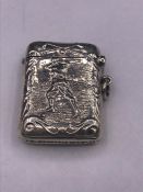 A silver vesta case with embossed image of a golfer