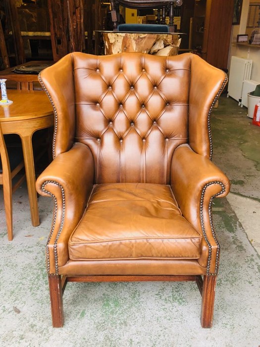 A Brown Leather button backed winged back Club chair