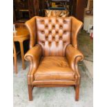 A Brown Leather button backed winged back Club chair
