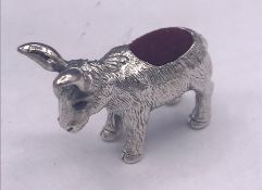 A silver pincushion in form of a donkey with ruby eyes