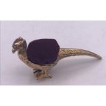 A brass pincushion in the form of a pheasant