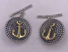 A pair of silver cufflinks in the Versace style with gold anchors