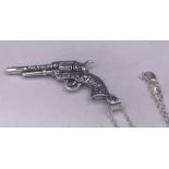 A silver hand gun pendant on a silver chain