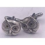 A pair of silver owl cufflinks in the form of owls with glass eyes