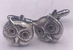 A pair of silver owl cufflinks in the form of owls with glass eyes