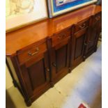 A Mahogany sideboard with four cupboards with four drawers.