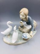 A Lladro figure of a girl feeding geese.