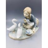 A Lladro figure of a girl feeding geese.