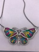 A silver plique jour butterfly necklace on silver chain
