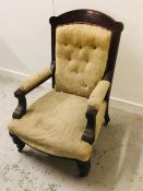 A Mahogany Victorian armchair with carved back and button back upholstery.