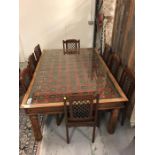 A large glass topped table made from an Antique Asian roof panel with eight chairs.