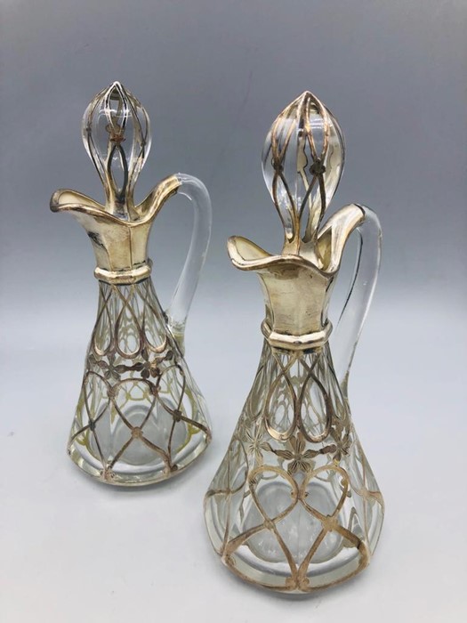 A pair of silver and glass oil bottles.