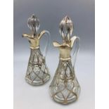 A pair of silver and glass oil bottles.