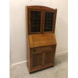 A light Oak Bureau bookcase with upper glazed doors in an Arts and Crafts style.