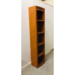 A Tall slim contemporary unit with four shelves with detailed edges.