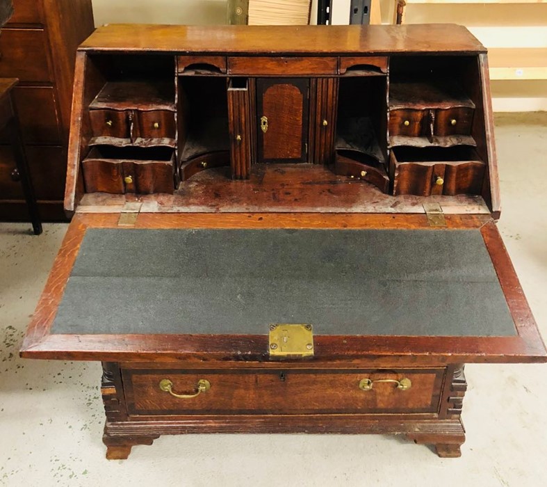 A George III oak crossbanded bureau, the fall enclosing a stepped interior with serpentine drawers - Image 2 of 2