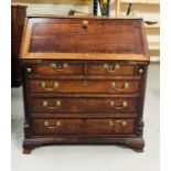 A George III oak crossbanded bureau, the fall enclosing a stepped interior with serpentine drawers