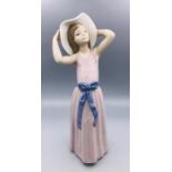 A Lladro figure of a lady in pink dress with a sun hat