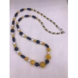 A necklace of fresh water pearl and onyx spacers with silver clasp