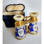 A cased pair of Edwardian gilt metal opera glasses with finely floral-enamelled barrels and mother-