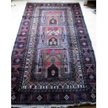 An Afghan hand-knotted Herathi Balochi maroon-ground wool rug with multi-coloured designs, double