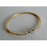 A 9ct gold bangle set with simulated diamonds and a 'Forever' knot 7.94g