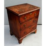 A Queen Anne-style walnut smaller chest of three drawers with tear-drop brass drop handles raised on