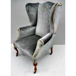 A Queen Anne-style walnut-framed fabric upholstered wing back fireside armchair on cabriole legs and