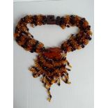 A multi-stranded amber beaded necklace with pendant, 180g