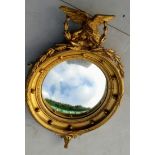 A Regency gilt convex wall mirror with applied eagle and laurel decoration, 40cm diameter, 90cm H