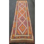 A Suzani hand-knotted Kilim wool runner with multicoloured decoration, 285 x 80 cm in good