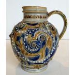 A Doulton Lambeth Arthur B Barlow stoneware jug, decorated in blue and brown foliage scrolls with