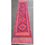 An Afghan hand-knotted blue-ground Meshwani wool runner with multi-coloured isometric decoration, 61