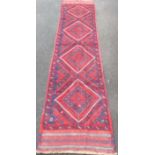 An Afghan burgundy-ground Meshwani hand-knotted wool runner with multicoloured isometric