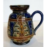 A Doulton stoneware jug by George Hugo Tabor and Harriet E. Hibbut, the baluster body decorated with