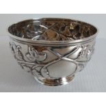 A Victorian silver bowl embossed with leaves and vines on a single foot, dedication to cartouche, by