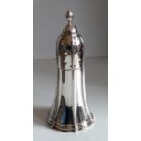 A George V silver sugar caster of conical form with fluted decoration, pierced fluted cover and