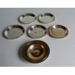 Five matching circular silver coasters or trays with carved rims by Charles S Green & Co Ltd,