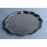 A George V silver circular tray with pie-crust border, engraved dedication, by Gorham